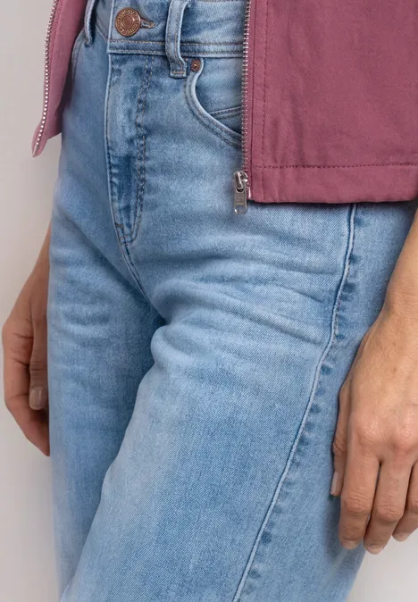 High Waist Barrel Leg Jeans im Loose Fit Light Blue Wash Eine Person trägt eine hellblaue Jeans und einen rosa Pullover, sichtbar sind Taille und Hand.