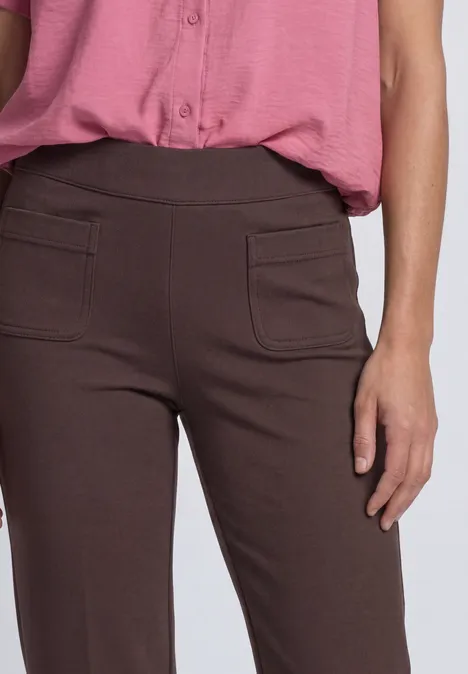 High Waist Straight Leg Hose im Casual Fit ruby vine Frau trägt braune Hose mit aufgesetzten Taschen und eine rosa Bluse.
