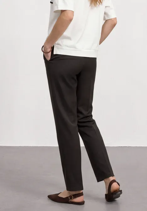 High Waist Straight Leg Hose im Casual Fit black coffee Rückansicht einer Person in schwarzen, lässigen Hosen und braunen Sandalen.