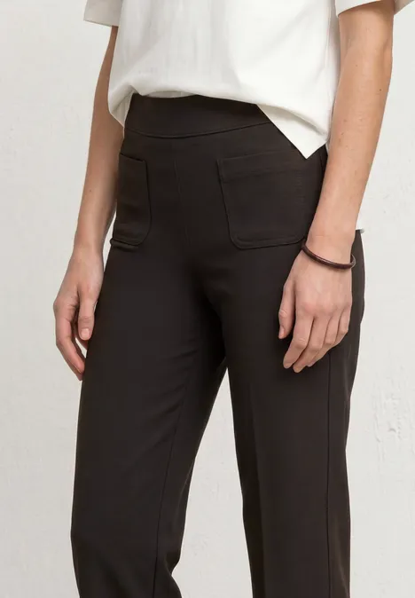 High Waist Straight Leg Hose im Casual Fit black coffee Schlanke schwarze Hose mit aufgesetzten Taschen, eng anliegend, kombiniert mit weißem Oberteil.