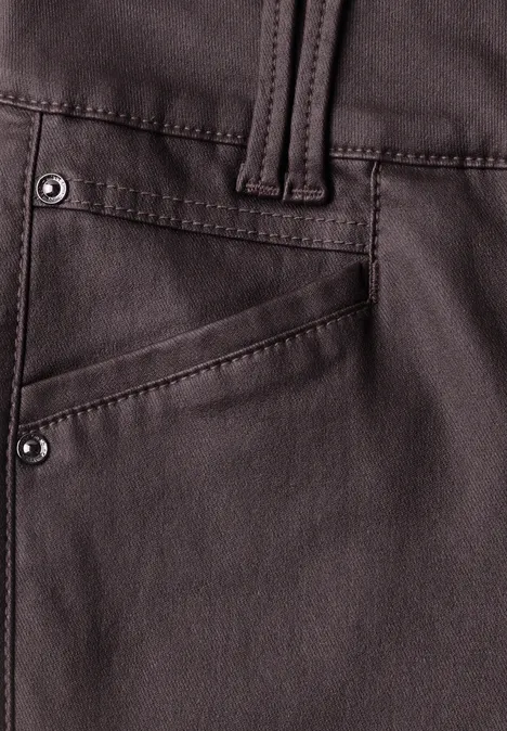 Nahaufnahme einer dunkelbraunen Lederhose mit Tasche und Nieten.