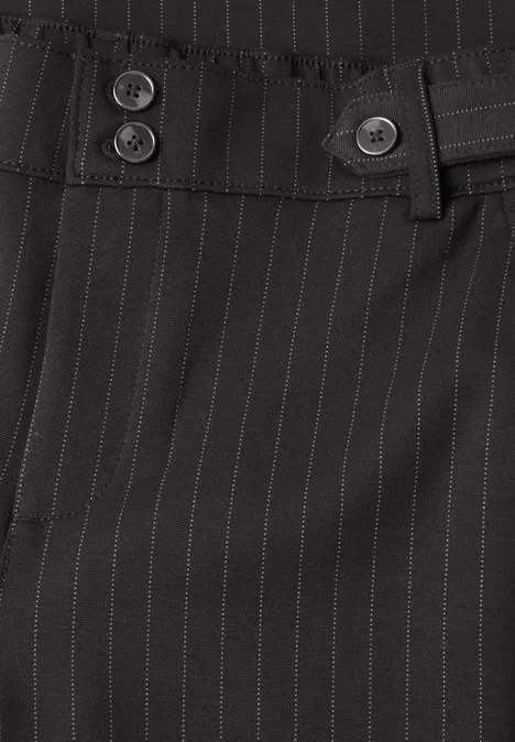 Pantalon de costume noir à fines rayures grises, taille à deux boutons et passants de ceinture.