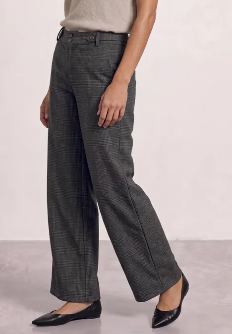 Pantalon ample vert foncé taille haute, porté avec des ballerines noires.