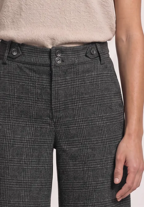 Personne porte un pantalon à carreaux gris avec double bouton et haut beige.