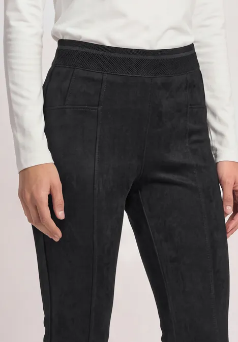Pantalon noir en velours côtelé taille haute avec coutures apparentes.