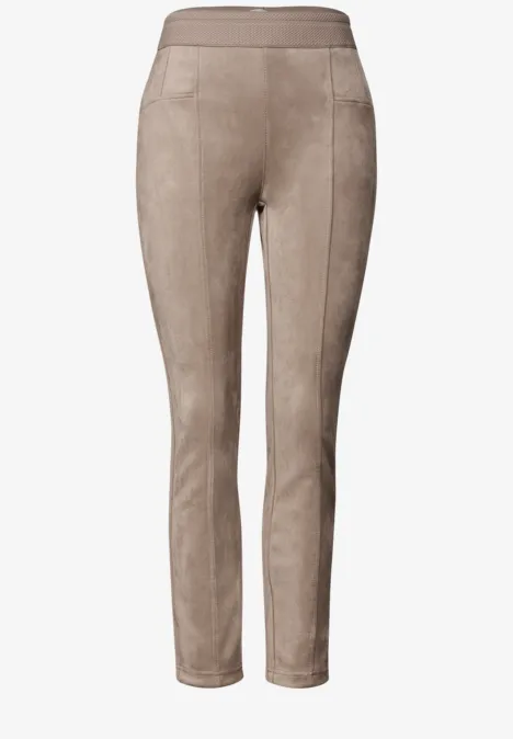 Beige suède-leggings met hoge taille, aansluitende pijpen en subtiele stiknaden.
