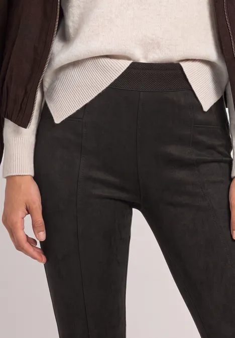 Leggings noirs ajustés avec couture subtile à l’avant, portés avec un haut clair.