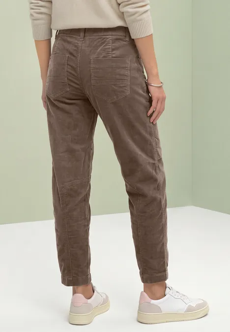 Barrel Leg Hose aus Cord im Casual Fit velvet mocha Person von hinten in braunen Cordhosen und weißen Sneakern vor hellem Hintergrund.