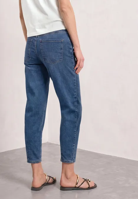 High Waist Barrel Leg Jeans im Loose Fit Medium Blue washed Person von hinten in blauen Jeans und schwarzen Riemchensandalen vor neutralem Hintergrund