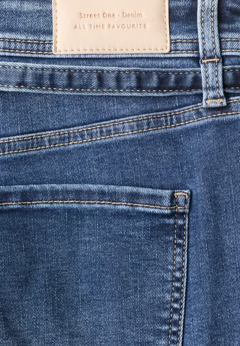 Straight Leg Jeans mit Gürtel Mid Blue Random Washed Nahaufnahme einer blauen Jeans mit sichtbaren Nähten, Gesäßtasche und Lederetikett.