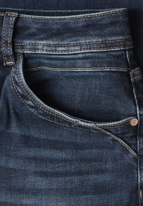 Nahaufnahme einer dunkelblauen Jeans mit sichtbarer Tasche und Naht.
