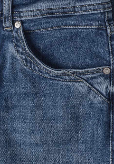 Nahaufnahme einer blauen Jeansvorderseite mit Tasche und sichtbarer Naht.