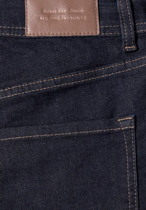 Gros plan d'un jean bleu foncé montrant une poche arrière et une étiquette en cuir