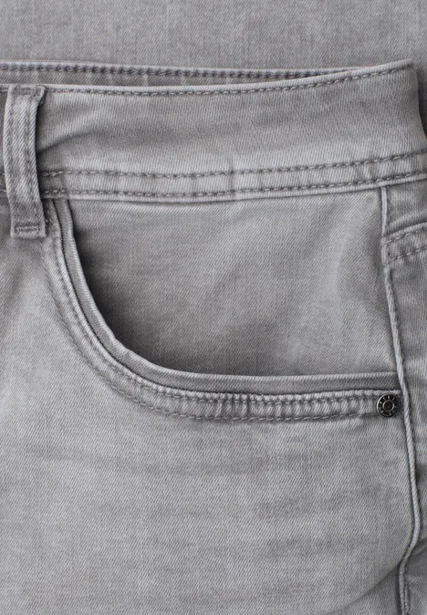 Graue Jeans-Front mit Hosentasche, Gürtelschlaufen und Nahtdetails.