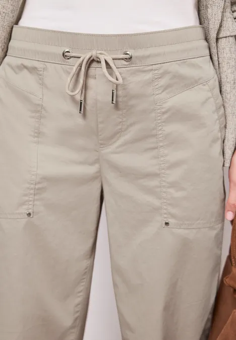 Heller, beiger Baumwoll-Jogginghose mit Tunnelzug, seitlichen Taschen und geraden Beinform.