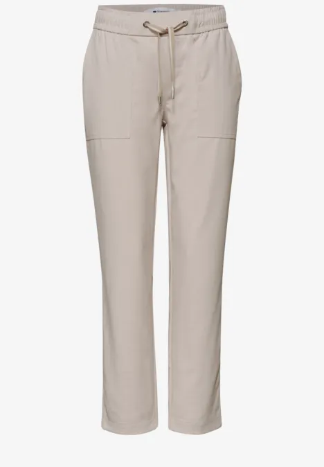 Pantalon décontracté beige à taille élastique avec cordon et poches latérales.
