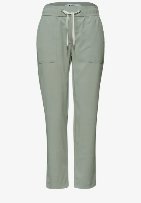 Helle, salbeigrüne Hose mit Gummibund, Tunnelzug und aufgesetzten Taschen – lässig und bequem.