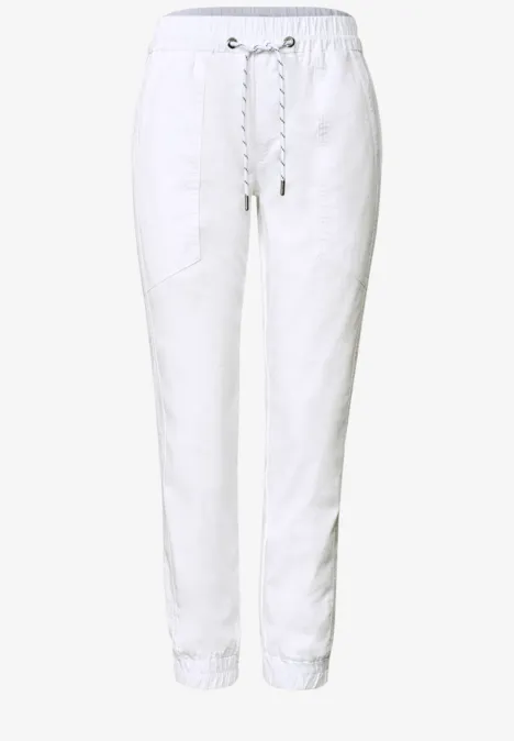 Weiße Leinen-Jogginghose mit Kordelzug, seitlichen Taschen und elastischen Bündchen.