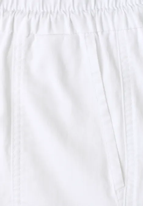 Nahansicht einer weißen Hose mit elastischem Bund und seitlicher Tasche.