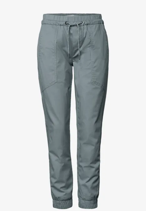 Hellgraue Jogginghose mit Gummibund, Kordelzug und elastischen Bündchen an den Knöcheln.