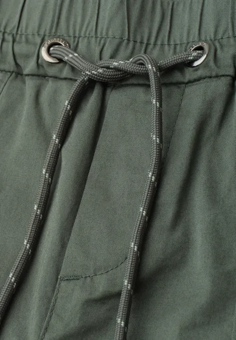 Nahaufnahme einer dunkelgrünen Hose mit elastischem Bund und grauem Kordelzug.