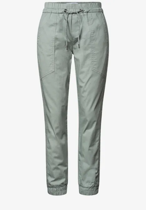 Leichte olivgrüne Hose mit Tunnelzugbund, seitlichen Taschen und elastischen Beinabschlüssen.