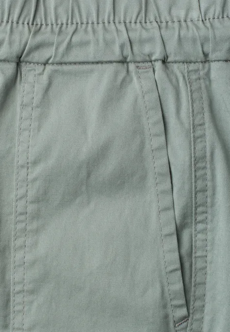 Nahaufnahme einer hellgrauen Hose mit elastischem Bund und seitlicher Tasche.