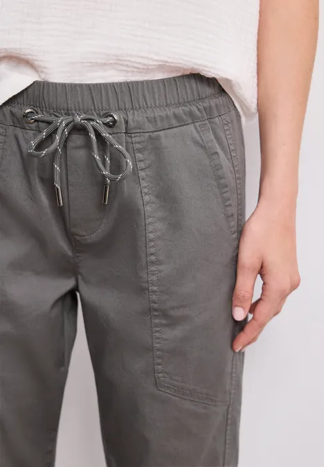 Olivegrüne Cargohose mit elastischem Kordelzugbund und aufgesetzten Taschen.