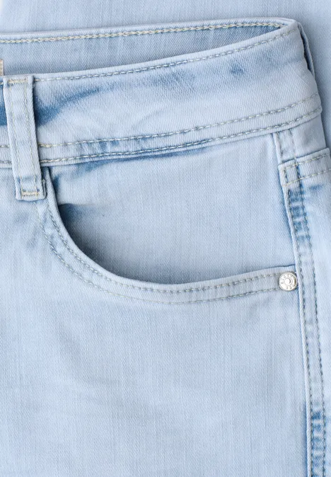 Gros plan sur un jean bleu clair avec poche avant et passants de ceinture.