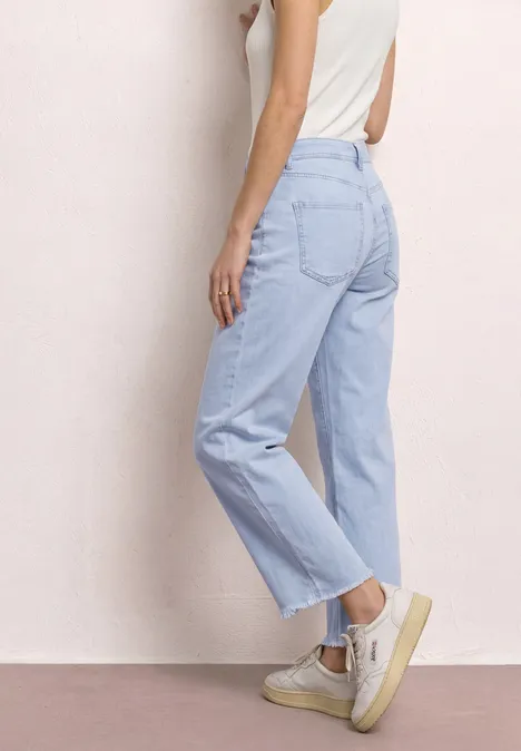 Seitenansicht einer Frau, die hellblaue, gerade geschnittene Jeans mit hohem Bund trägt.