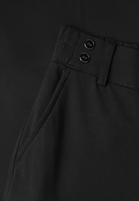 Schwarze Hose, Detailansicht mit seitlicher Eingrifftasche, Gürtelschlaufen und zwei Knöpfen am Bund.