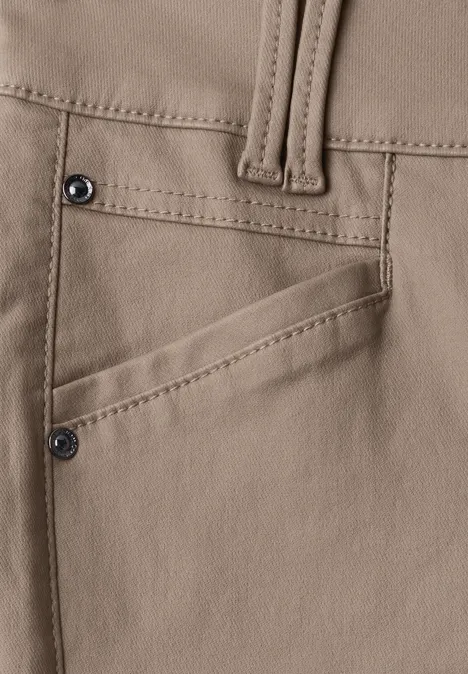Gros plan d’un pantalon beige avec poche inclinée et rivets