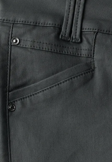 Gros plan d’un pantalon en cuir noir avec passants de ceinture et poche latérale.