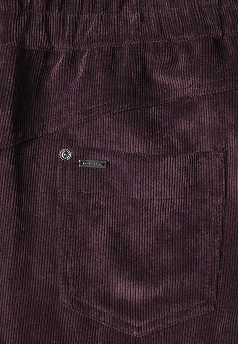 Mid Waist straight leg corduroybroek met rechte pijpen en middelhoge taille vintage ruby Close-up van een paarse corduroybroek met zakje en metalen label.
