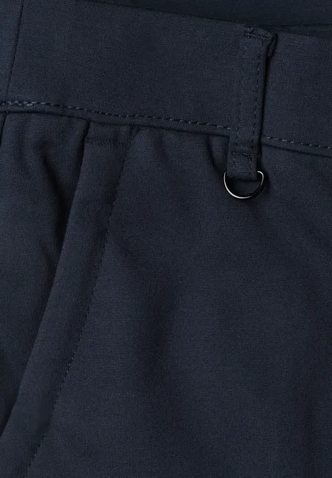 Gros plan d’un pantalon bleu foncé avec passants de ceinture et petit anneau métallique.