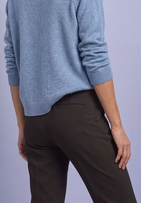 Vue de dos d’une personne portant un pull bleu et un pantalon sombre.