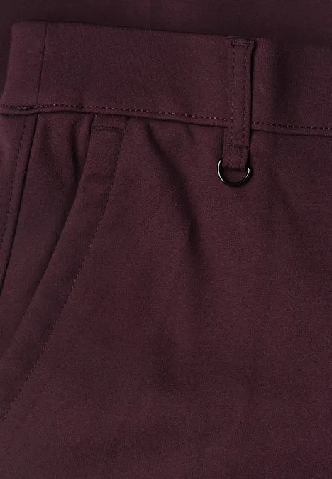 Spodnie chino Slim Leg z brokatowymi akcentami vintage ruby Zbliżenie bordowych spodni ze szlufkami, karabińczykiem typu D i boczną kieszenią.
