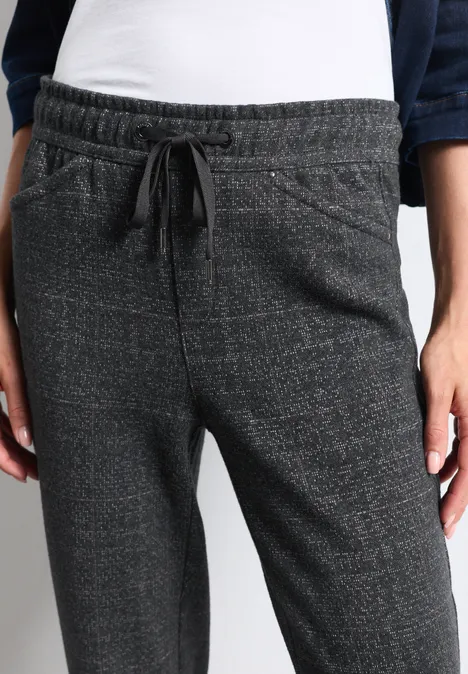 Pantalon de jogging gris avec cordon et poches latérales porté par une personne