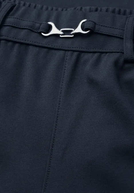Dunkelblaue Hose mit verstellbarem, schraubenschlüsselähnlichem Metallverschluss am Bund