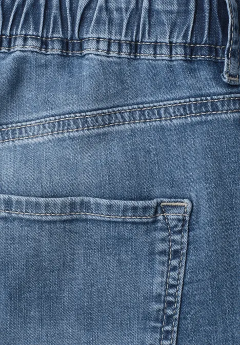 Mid Waist Jeansculotte met elastische tailleband Mid Blue Authentic washed Close-up van een blauwe spijkerbroek met achterzak en zichtbare stiksels.