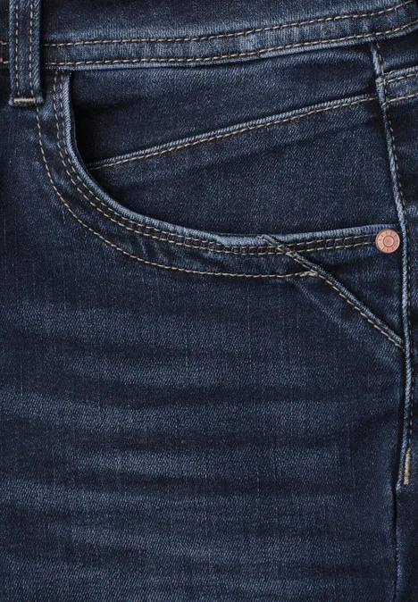 Mid Waist Slim Leg Jeans im Casual Fit Dark Blue Clean washed Nahaufnahme einer dunkelblauen Jeans mit sichtbarer Fronttasche, Münztasche, Naht und Metallniete.
