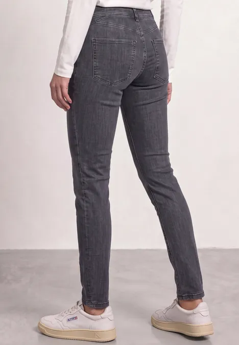 Mid Waist Slim Leg Jeans im Casual Fit Steel Grey Wash Rückansicht einer Person, die dunkelgraue, karierte Slim-Hose und weiße Sneaker trägt.