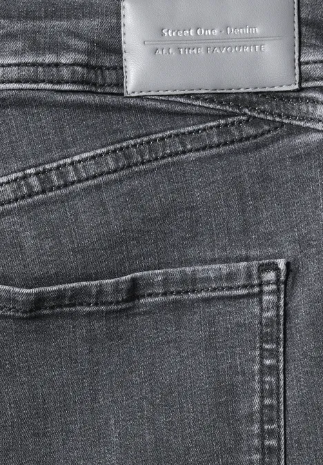 Mid Waist Slim Leg Jeans im Casual Fit Steel Grey Wash Nahe Aufnahme einer blauen Jeansrückseite mit Gesäßtasche und Lederetikett.