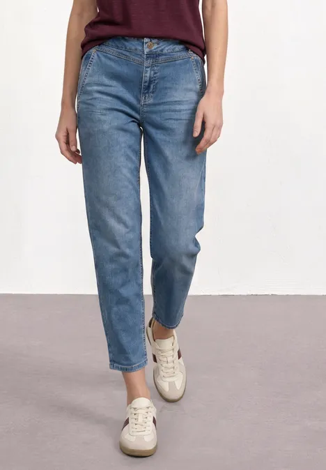 Cowboyjeans in mittlerer Taille und geradem Schnitt, kombiniert mit hellen Sneakern.