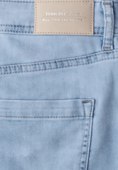 Lichtblauwe spijkerbroek met achterzak en beige merklabel in de tailleband.