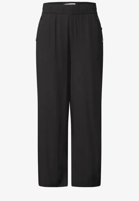 Schlichte, schwarze, gerade geschnittene Hose mit elastischem Bund und seitlichen Reißverschlusstaschen.