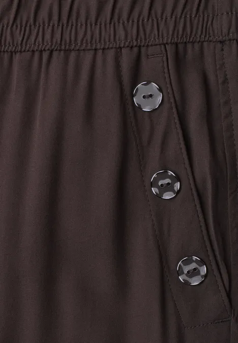 Dunkelbraune Hose mit elastischem Bund und drei Druckknöpfen an der Seite.