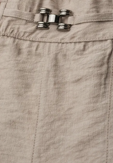 Helles Leinengewebe mit verstellbaren Metall-Schnallen, Detailaufnahme.