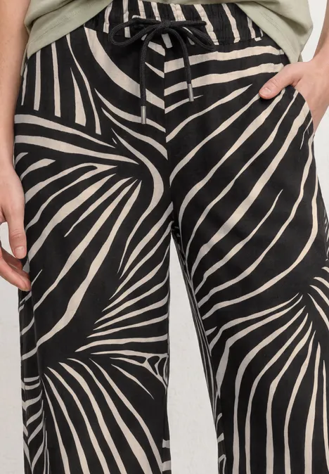 Schwarz-weiße, locker sitzende Hose mit Zebramuster, Tunnelzugbund und seitlichen Eingrifftaschen.