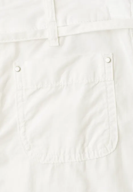 Nahaufnahme einer aufgesetzten Tasche an einer weißen Hose mit Gürtelschlaufen.